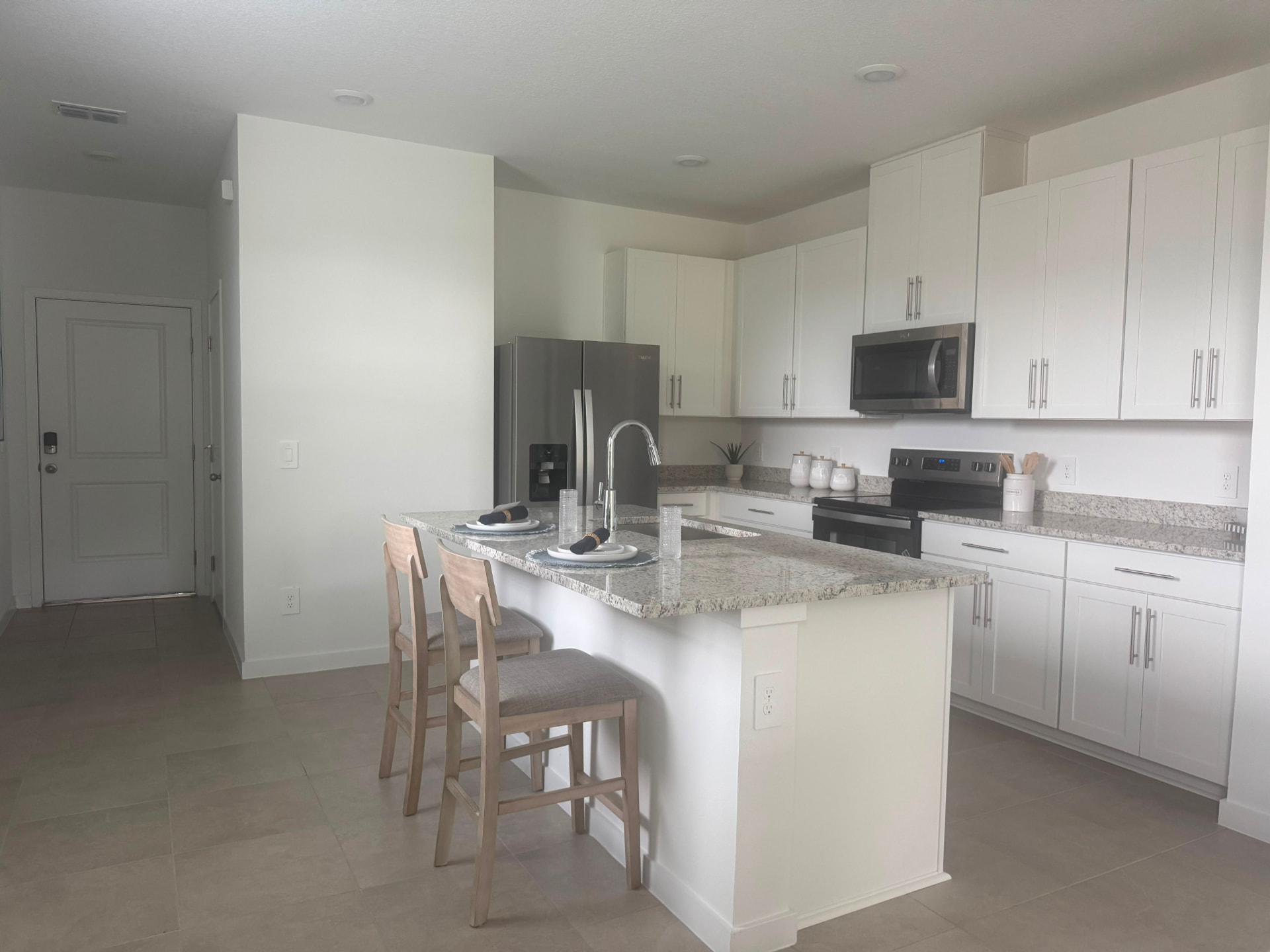 Bright new townhome kitchen with granite island and stainless appliances